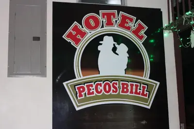 a sign for a rooster pegas bid on a building at Hotel Pecos Bill in San José