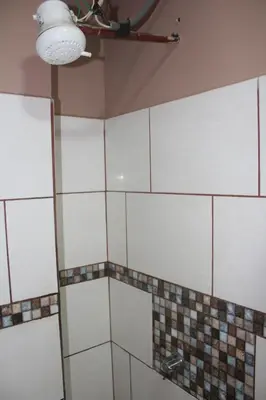 a bathroom with white tiles and a ceiling at Hotel Pecos Bill in San José