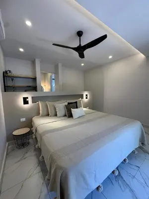 a bedroom with a large bed with a ceiling fan at Tamarindo Sunshine in Tamarindo