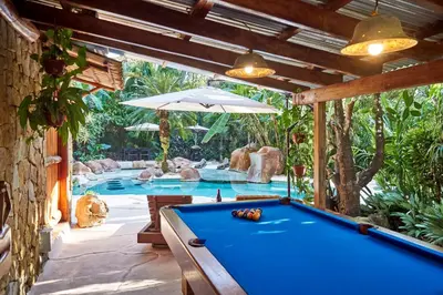 a pool table in front of a swimming pool at Havana Lodge in Mal País