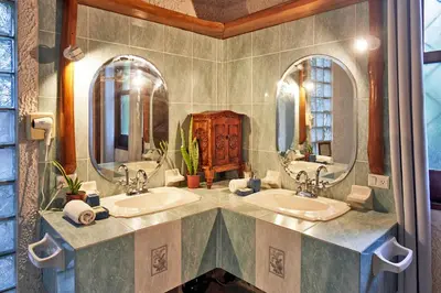 a bathroom with two sinks and two mirrors at Havana Lodge in Mal País