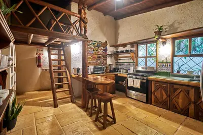 a kitchen with a wooden table and a stove at Havana Lodge in Mal País
