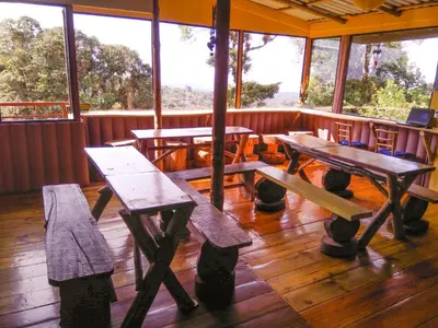a group of picnic tables in a room with windows at Iyok Ami (Madre Tierra) in Cartago