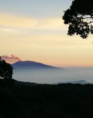 a mountain in the distance with a layer of fog in the sky at Iyok Ami (Madre Tierra) in Cartago