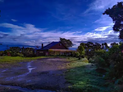 a barn on a field next to a dirt road at Iyok Ami (Madre Tierra) in Cartago