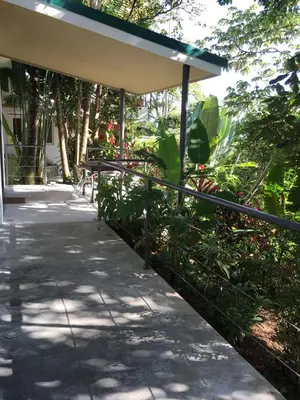 a walkway with a bench in front of a building at Casa Libertinn in Manuel Antonio
