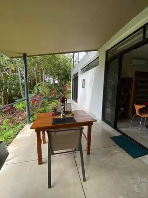a wooden table and a chair on a patio at Casa Libertinn in Manuel Antonio
