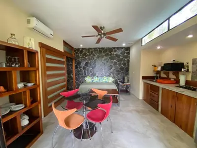 a kitchen with a table and some red chairs at Casa Libertinn in Manuel Antonio