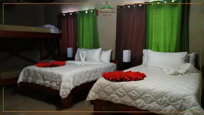 two beds in a room with green curtains at Mountain Faro Hotel in Monteverde Costa Rica