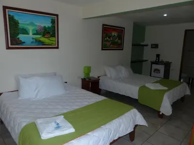 a hotel room with two beds with towels on them at Mountain Faro Hotel in Monteverde Costa Rica