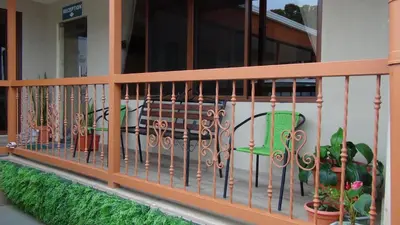 a balcony with a fence with plants and a bench at Mountain Faro Hotel in Monteverde Costa Rica