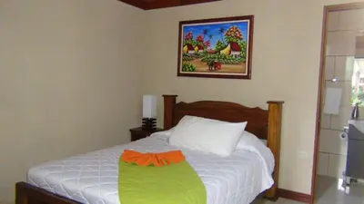 a bedroom with a bed with an orange bow on it at Mountain Faro Hotel in Monteverde Costa Rica