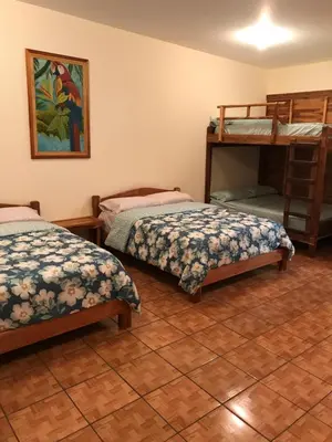 a bedroom with two beds and a bunk bed at Hotel Cabañas La Teca in Liberia