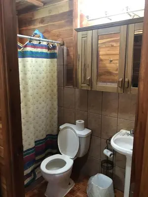 a bathroom with a toilet and a sink at Hotel Cabañas La Teca in Liberia