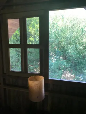 a lamp in a room with two windows at Hotel Cabañas La Teca in Liberia