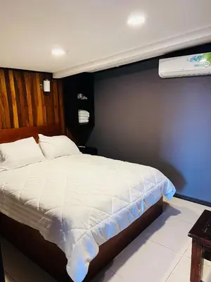 a bedroom with a white bed and a blue wall at Don Jarvey I Bed & Breakfast in Monteverde Costa Rica