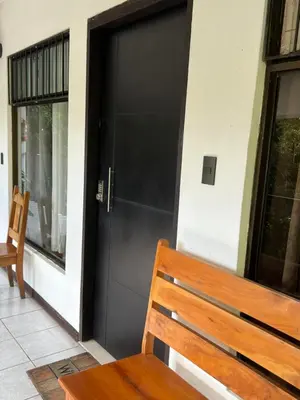 a wooden bench sitting in front of a door at Don Jarvey I Bed & Breakfast in Monteverde Costa Rica