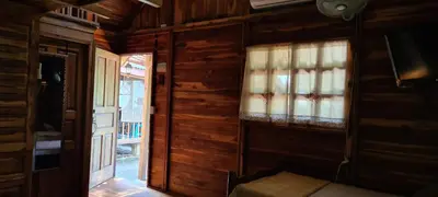a living room with wooden walls and a window at Congos Hostal y Camping in Playa Hermosa