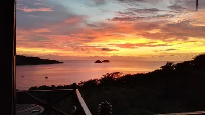 a sunset over a body of water with the ocean at Congos Hostal y Camping in Playa Hermosa
