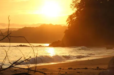 a sunset on a beach with the sun setting at Ocean View Echemare Tango Mar in Tambor