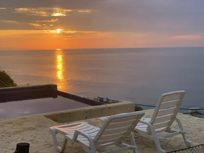 two white chairs sitting on the beach at sunset at Ocean View Echemare Tango Mar in Tambor