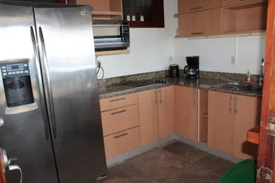 a kitchen with a stainless steel refrigerator and wooden cabinets at Ocean View Echemare Tango Mar in Tambor