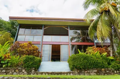 a house with a palm tree in front of it at Jodokus Inn in Montezuma