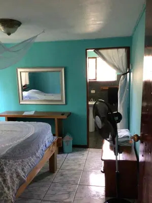 a bedroom with a bed and a mirror on the wall at Jodokus Inn in Montezuma