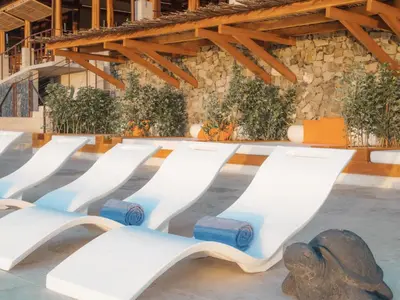 a row of white benches in a pool at Casa Chameleon Hotel Las Catalinas - Adults Only in Playa Flamingo