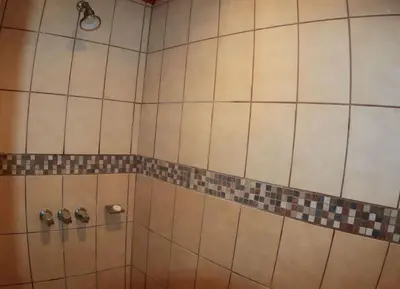 a shower with tiled walls and a shower head at Oceanview Studio Apartment with Community Pool & Views of Flamingo Marina in Playa Flamingo