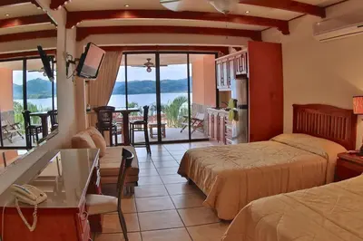 a hotel room with two beds and a view of the ocean at Oceanview Studio Apartment with Community Pool & Views of Flamingo Marina in Playa Flamingo