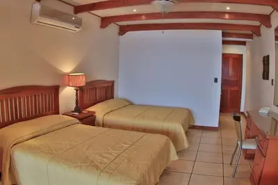 a bedroom with two beds and a table with a lamp at Oceanview Studio Apartment with Community Pool & Views of Flamingo Marina in Playa Flamingo