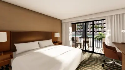 a bedroom with a bed and a desk and a balcony at Holiday Inn San Jose La Sabana by IHG in San José