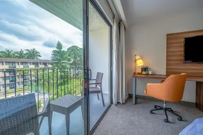 a hotel room with a desk and a balcony with a view at Holiday Inn San Jose La Sabana by IHG in San José