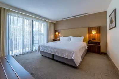 a hotel room with a bed and a large window at Holiday Inn San Jose La Sabana by IHG in San José