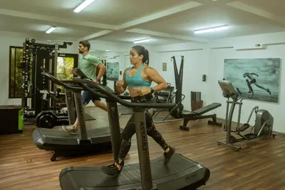 a man and a woman running on tread machines in a gym at Paradise Hot Springs - Thermal Water & Volcano Views in Fortuna