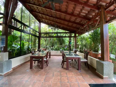 an outdoor patio with tables and chairs and windows at Paradise Hot Springs - Thermal Water & Volcano Views in Fortuna