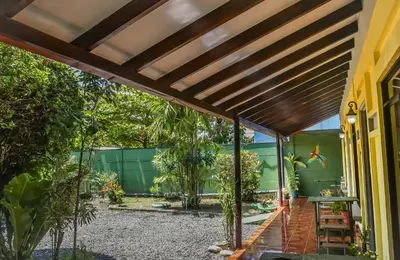 an external view of a house with a wooden pergola at Cabinas Bahía Uvita - Marino Ballena National Park Lodge in Uvita