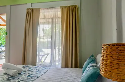 a bedroom with a bed and a large window at Cabinas Bahía Uvita - Marino Ballena National Park Lodge in Uvita