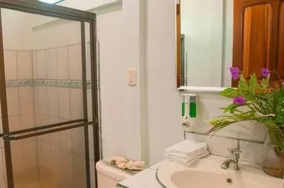 a bathroom with a sink and a toilet and a shower at Cabinas Bahía Uvita - Marino Ballena National Park Lodge in Uvita