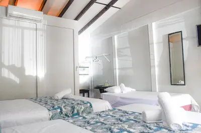 a room with two beds and a table in it at Cabinas Bahía Uvita - Marino Ballena National Park Lodge in Uvita