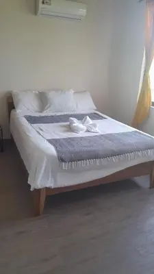 a bed with two white shoes on top of it at Sunshine Sanctuary Boutique Jungle Lodge in Montezuma