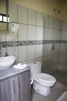 a bathroom with a toilet and a sink and a shower at Sunshine Sanctuary Boutique Jungle Lodge in Montezuma