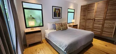a bedroom with a bed with two lamps and two windows at Boutique Hotel y Spa Tangara Azul in Ojochal