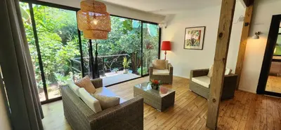 a living room with furniture and a large window at Boutique Hotel y Spa Tangara Azul in Ojochal