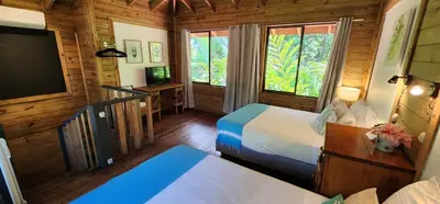 a bedroom with two beds and a flat screen tv at Boutique Hotel y Spa Tangara Azul in Ojochal