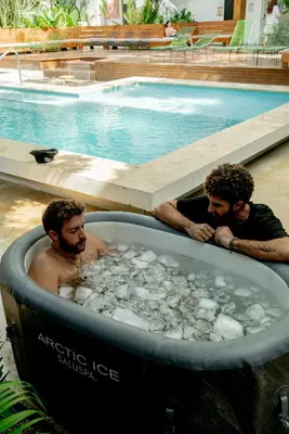 two men in a tub of rocks in a swimming pool at ESO Santa Teresa in Santa Teresa Beach