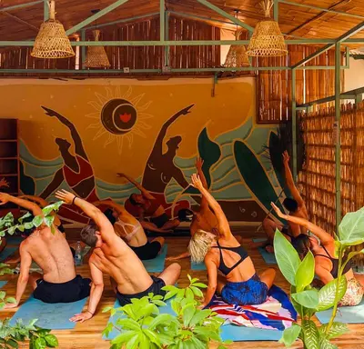 a group of people doing yoga in a room at ESO Santa Teresa in Santa Teresa Beach