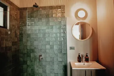 a bathroom with a shower with a sink and a mirror at Armonia Santa Teresa in Santa Teresa Beach