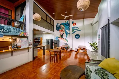 a living room with a large painting on the wall at Sandy Toes Hostel in Sámara